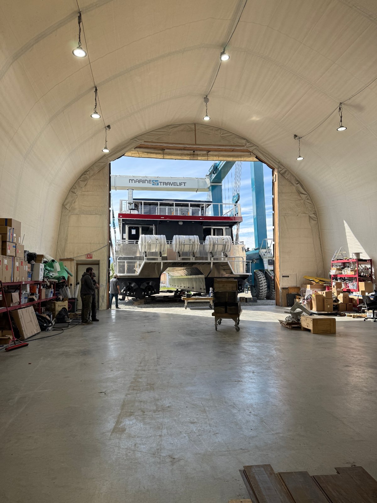 Boat inside the arched Bay Weld shop with the doors open